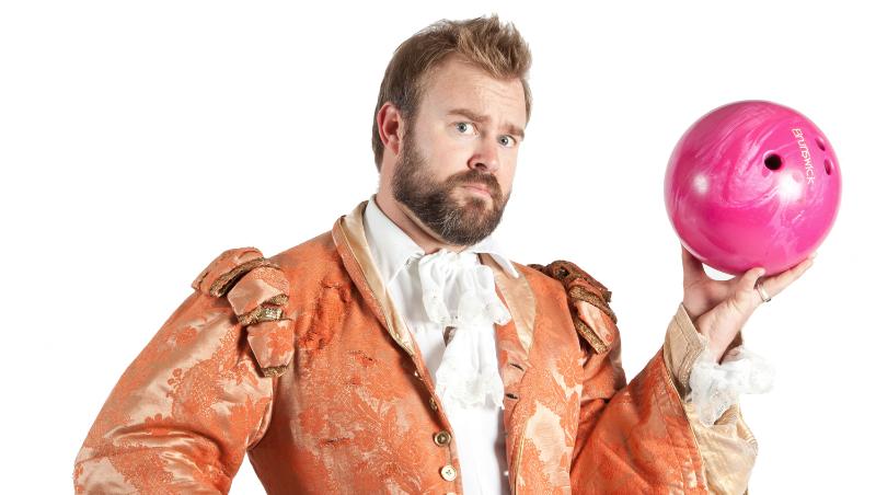 Jaimie Robertson, dressed in colourful Shakespearean garb, holds a pink bowling ball in his left hand